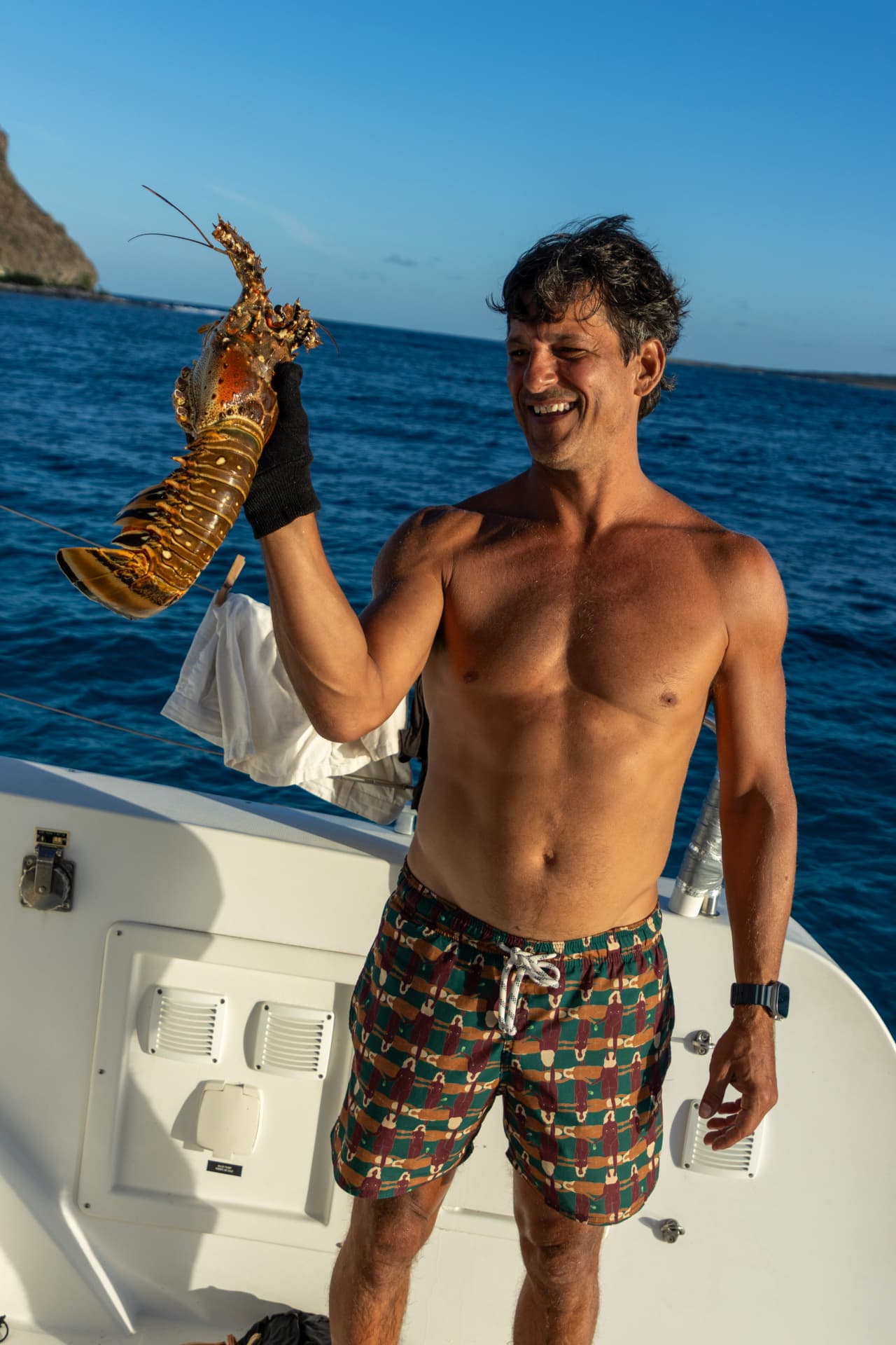 A guest holding the day's fresh lobster catch on deck