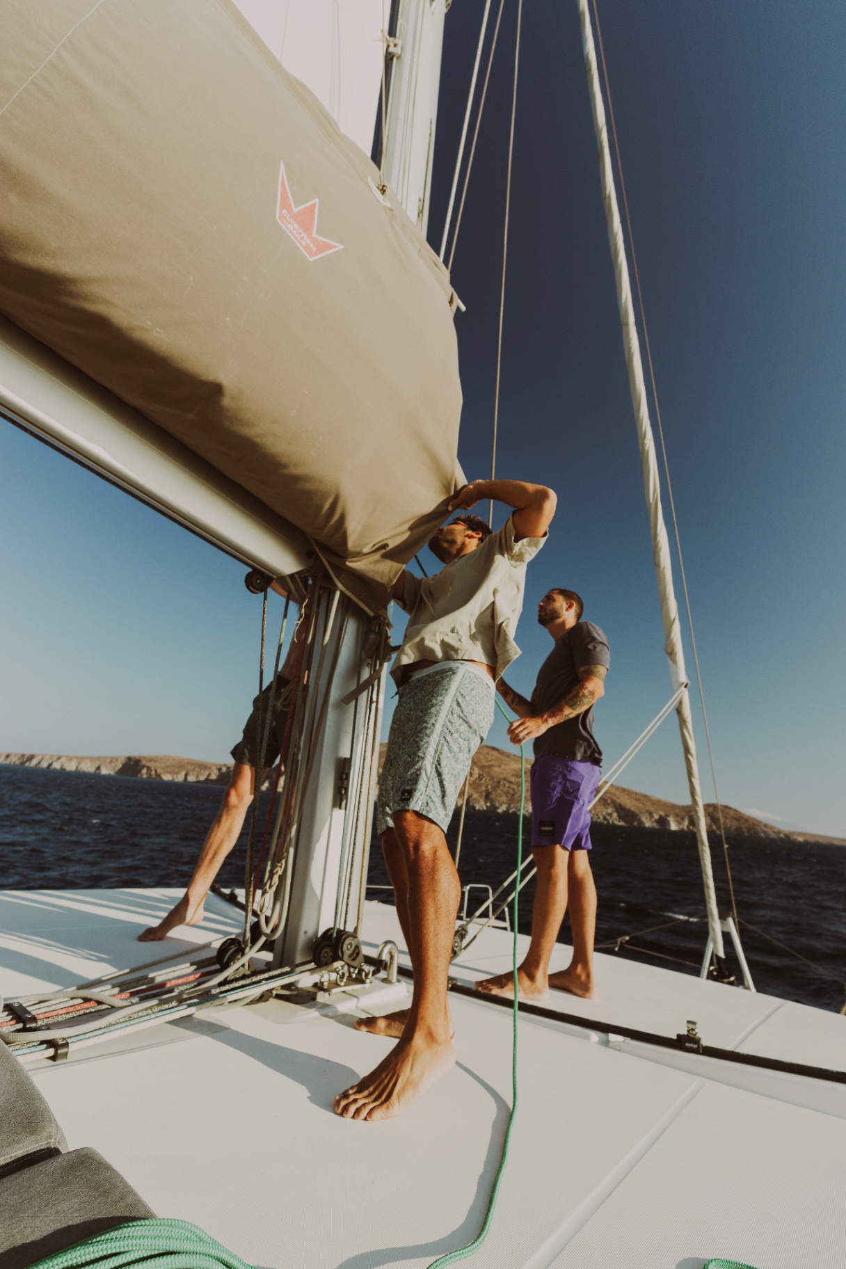 Crew hoisting the mainsail on the catamaran