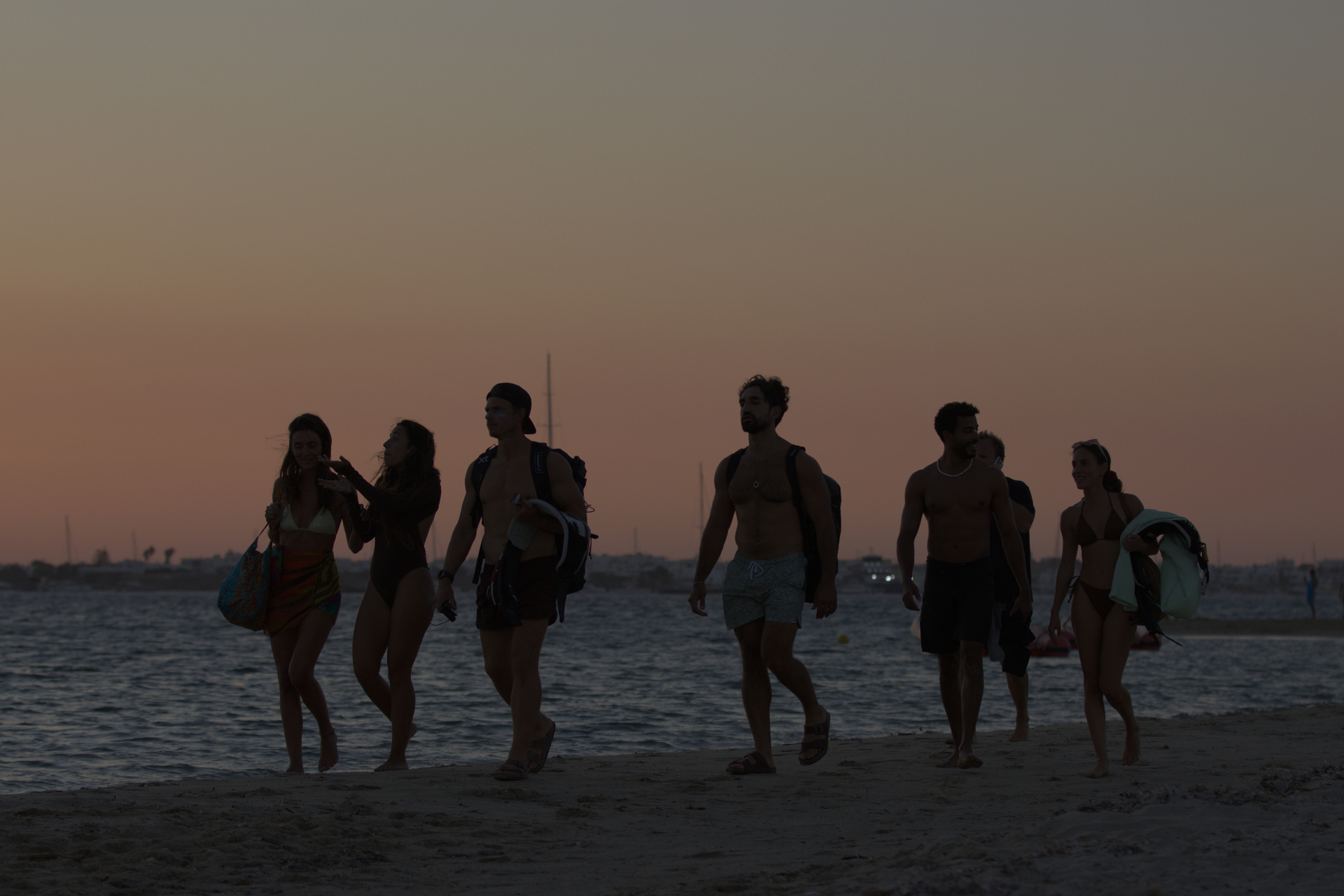 Group walking the beach at sunset after a session